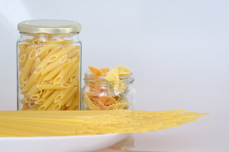 Pasta in glass jars on a gray background, selective focus