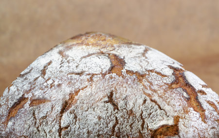 A quarter of rye bread on a background with beige paper in horizontal format
