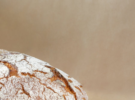 Background with beige craft paper and a piece of rye bread with copy space in horizontal format