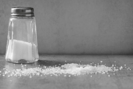 Gray background with a salt shaker with copy spaceの写真素材