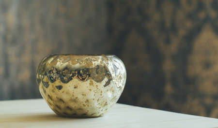 Vase with a texture under gold on a blurred background wall with wallpaperの写真素材