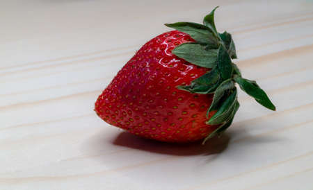 Whole Strawberry on wooden surfaceの写真素材
