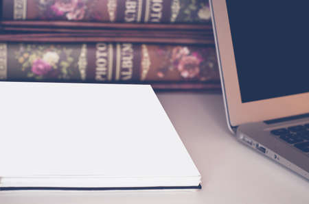 Business composition of photo albums on the table with a laptop and notepad