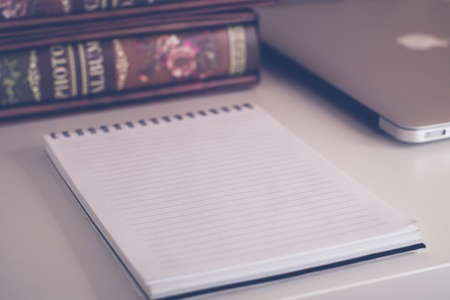 Business composition of photo albums on the table with a laptop and notepadの写真素材