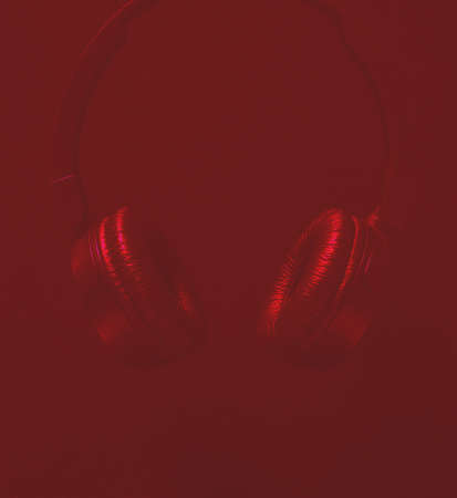 Black headphones on a red background for inscriptionの写真素材