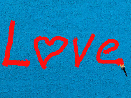 The inscription in red letters LOVE on a textural blue backgroundの写真素材