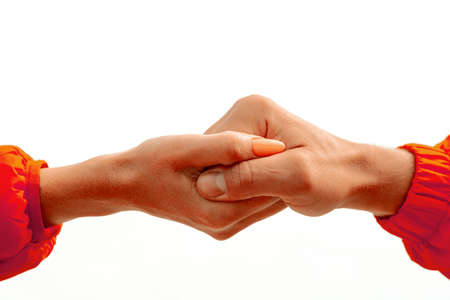 Female hand with red sleeve intertwined with male hand in red sleeve