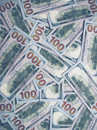 Chaotically spread out one hundred dollar bills. Background of chaotically scattered billsの写真素材