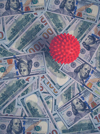Red ball of coronavirus on banknotes. Covid red ball lies on banknotesの写真素材