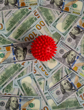 Red ball of coronavirus on banknotes. Covid red ball lies on banknotesの写真素材