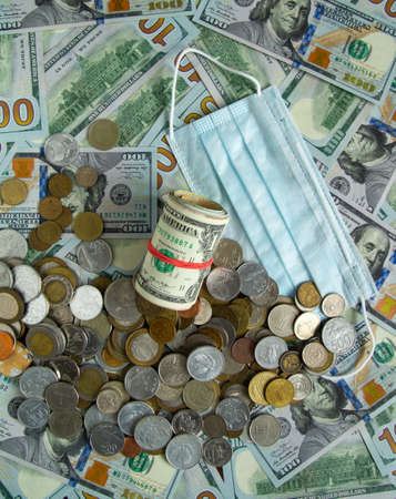 A white covid 19 mask lies on the banknotes. Coronavirus mask lies on banknotesの写真素材
