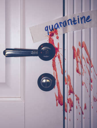 quarantine inscription on a wooden door. Blood splatters on the door. metal door handle