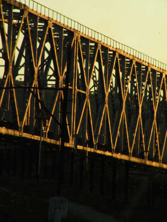 Railway bridge over the river at sunset