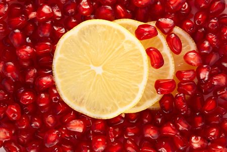 Lemon slices on pomegranate seeds backgroundの写真素材