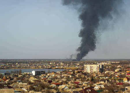 A huge black column of smoke resembling a giant poisonous mushroom above the city. Environmental...