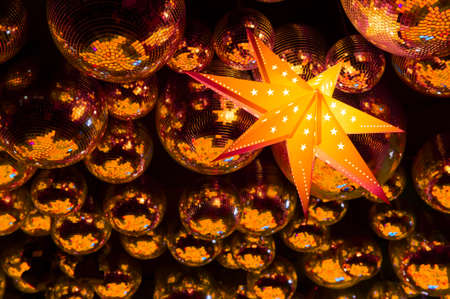 Nightclub gold disco balls and glowing yellow star in colorful festive lights in dance clubの写真素材