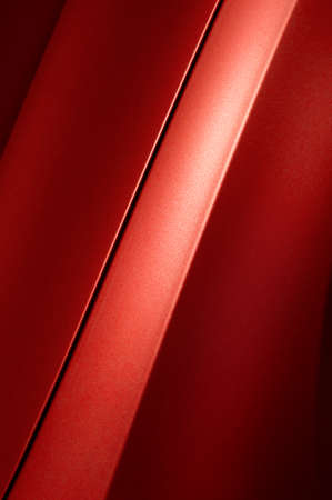 Fragment of red steel car bodywork, vehicle silver paint coating texture, selective focus, abstract