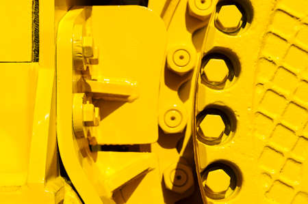 Track drive gear, bulldozer sprocket mechanism, large construction machine with bolts and yellow paint coating, heavy industry, detailの写真素材