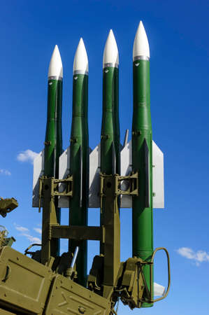 Ballistic missile launcher with four cruise missiles on powerful mobile transportation with blue sky and white clouds on background, antiaircraft forces, military industryの写真素材