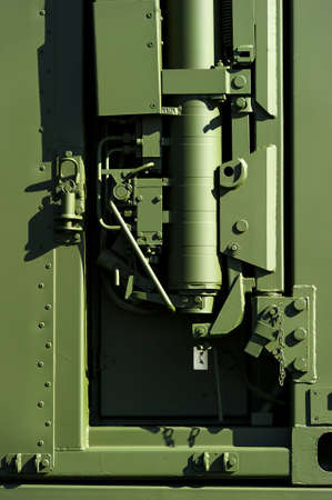 Military steel bodywork, green armored vehicle with detail of hydraulic lifting mechanism, rivets, bolts and screws, detail, army industryの写真素材