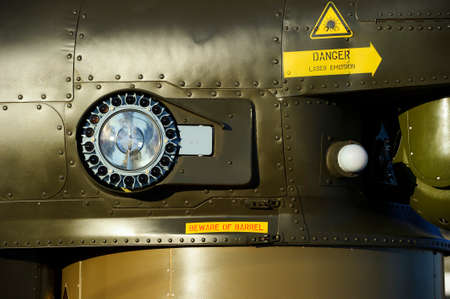 Headlight of military helicopter on armored side of green combat flying vehicle with rivets, air...