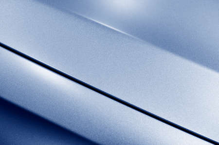 Surface of blue sport sedan car metal hood, part of vehicle bodywork, steel gradient line pattern, selective focusの写真素材