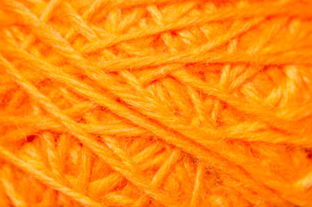 Woolen yarn ball, skein of tangled orange sewing threads, selective focusの写真素材