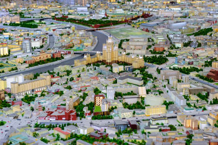 City scale model, dron view of town miniature, layout of urban space with houses and buildings with lights, highways, roads, river with bridges, streets, trees, transport traffic, architectural backgroundの写真素材