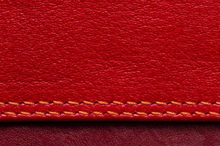 Leather samples with stitches, natural materials of red and maroon colors, seams with orange thread, woman bag detail, ro shot, abstract backgroundの写真素材