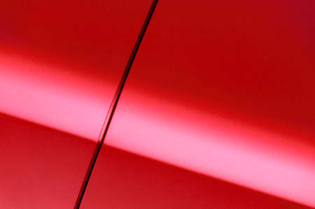 Surface of red sport sedan car, detail of metal hood, fender and door of vehicle bodyworkの写真素材
