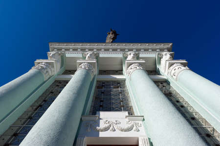 Columns of turquoise architectural building in classic style with a sculpture of bull, blue sky on backgroundの写真素材
