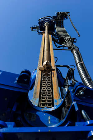 Drilling rig for boring holes, construction machinery, heavy industry, blue sky on background,...