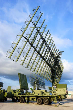 Air defense radars and locks of military mobile antiaircraft systems in green color, modern army industry, beautiful clouds and blue sky on backgroundの写真素材