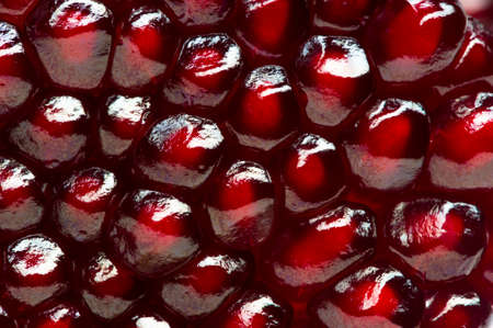 Pomegranate background, half of fresh juicy red garnet fruit, natural abstract texture, macro shotの写真素材