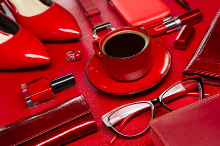Woman red accessories with coffee, cosmetic, jewelry, gadget and other luxury objects on leather background, fashion industry, modern female concept, selective focusの写真素材