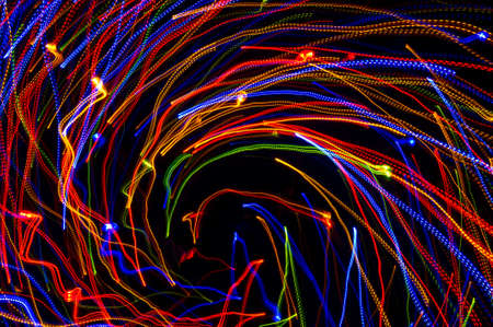 Swirling neon lights, bright whirling laser lights background, disco and dancing nightclubs rotating pattern, nightlife and party conceptの写真素材