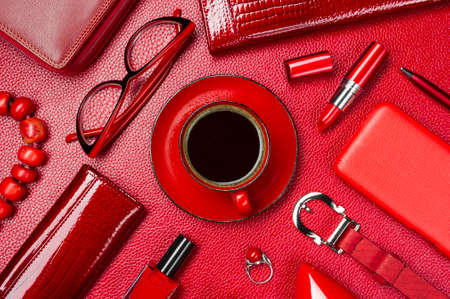 Woman red accessories with coffee, cosmetic, jewelry, gadget and other objects on leather background, fashion industry, modern female concept, selective focusの写真素材