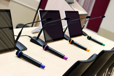 Conference room ready for business meeting, table with microphones and displays in row, selective focusの写真素材