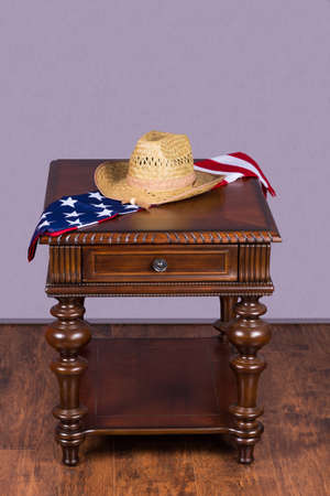 Wooden coffee table with hat and american flag on hardwood floor and gray backgroundの写真素材