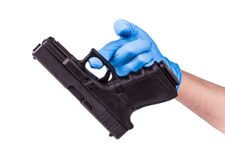 Hand in blue latex glove keeps handgun as evidenceの写真素材
