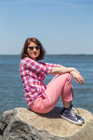 Girl on the beach with stonesの写真素材