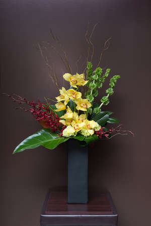 Floral arangement with Calla lilies, Cymbidium and James Storey orchids, Hydrangea, Curly willow, moluccella and greenery in rectangular black vaseの写真素材