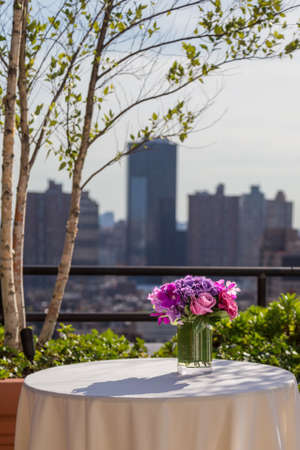 Floral arangement with pink Roses, Hydrangea, James Storey and Vanda Orchids on city background from rooftopの写真素材