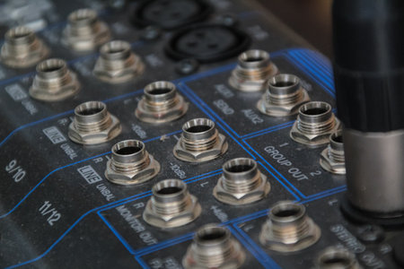 row of silver gold audio input connectors, on a professional audio mixing console or desk