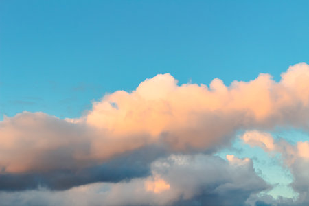 Dramatic clouds in the blue sky in the morning, the rising sun rays hitting the clouds