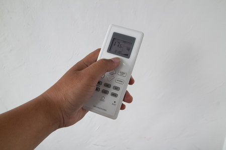 hand presses the button on the AC remote controlの写真素材