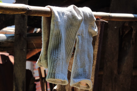 A white sock hanging and drying in the sun