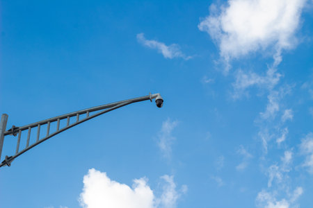 CCTV Security Camera on Pole Against Blue Sky