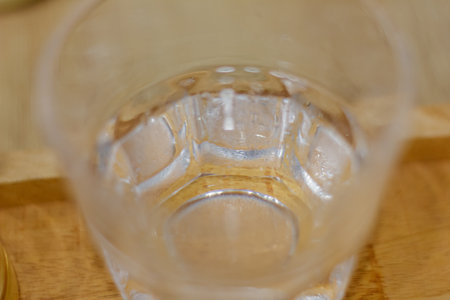 Close up of cold water glass with ice cubes and condensationの写真素材