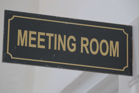 Meeting Room Sign with Gold Lettering on a Black Background Mounted on Wallの写真素材